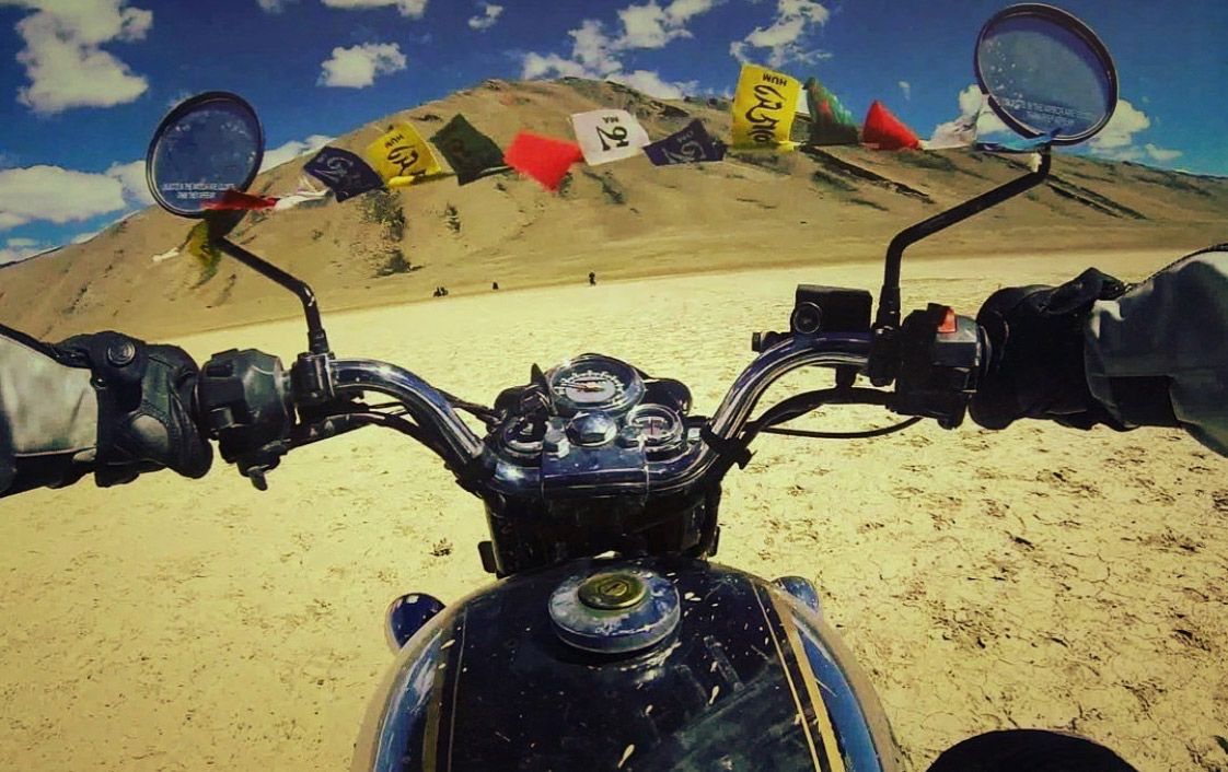 Tibetan prayer flags strung across the mirrors on this Royal Enfield Bullet near the city of Leh, India, nestled between Kashmir and Tibet.